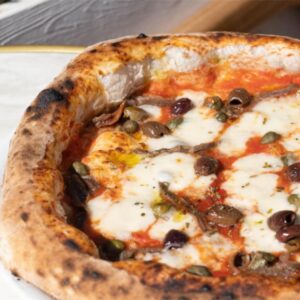 Pizza napolitaine artisanale Acciughe avec anchois, olives taggiasche, câpres, mozzarella fleur de lait et sauce tomate, servie chez 500 Degrés Pizza aux Grandes Halles du Vieux-Port à Marseille