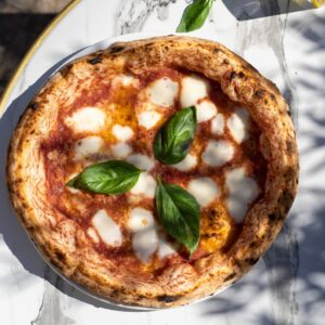 Pizza Margherita traditionnelle avec sauce tomate San Marzano, mozzarella fior di latte fondue et feuilles de basilic frais, servie chez 500 Degrés dans les Grandes Halles du Vieux-Port à Marseille.