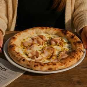 Pizza napolitaine garnie de mortadelle italienne, mozzarella fondante et éclats de pistaches, servie chez 500 Degrés aux Grandes Halles du Vieux-Port à Marseille.